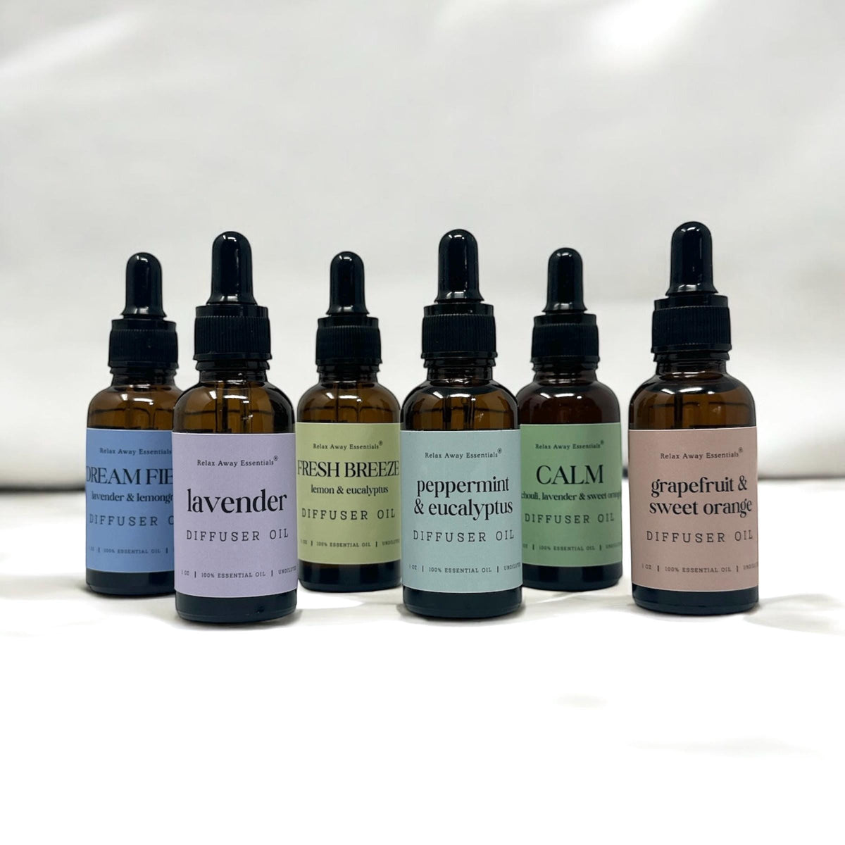 Row of diffuser oil bottles with labels on a white background