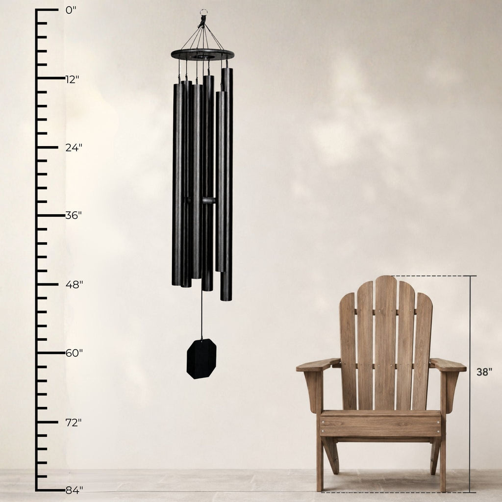 Black wind chime next to a wooden chair with measurements on a white background