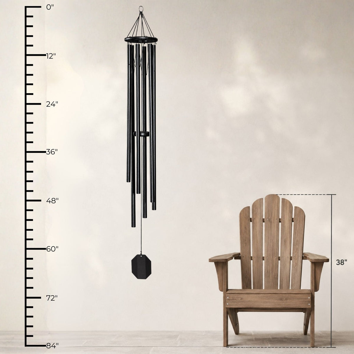 Black wind chime next to a wooden Adirondack chair with measurements on a light gray background
