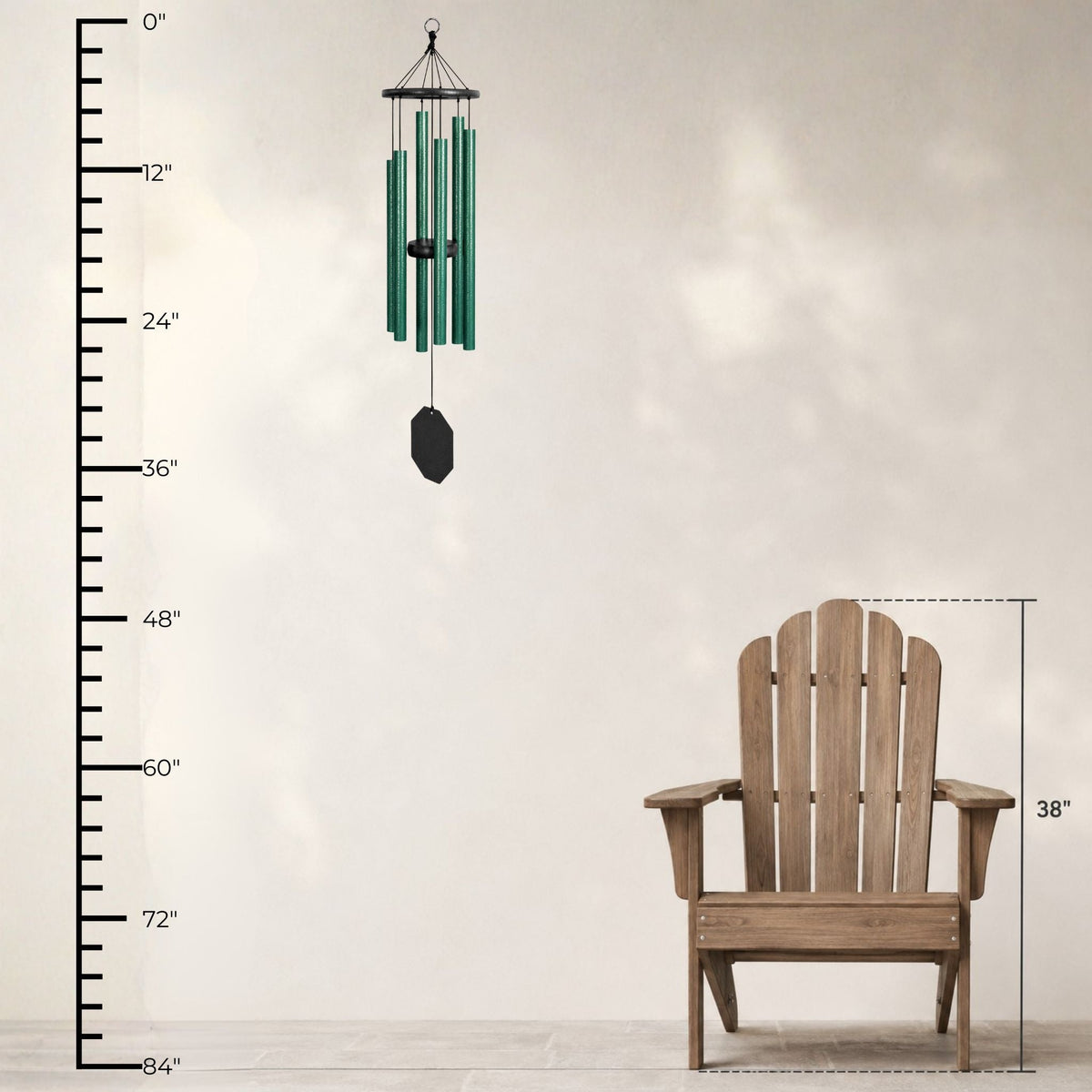 Green wind chime next to a wooden Adirondack chair with measurements on a neutral background