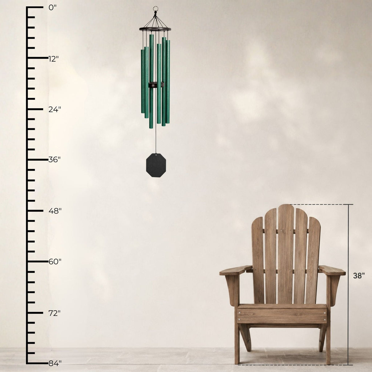 Green wind chime next to a wooden Adirondack chair with measurement scale on a light background