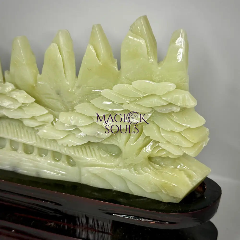 Green stone dragon sculpture on a stand with 'Magick Souls' branding.