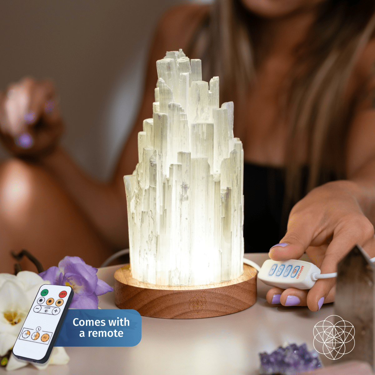 Picture of a Selenite Lamp with a person holding the light switch of the  lamp.