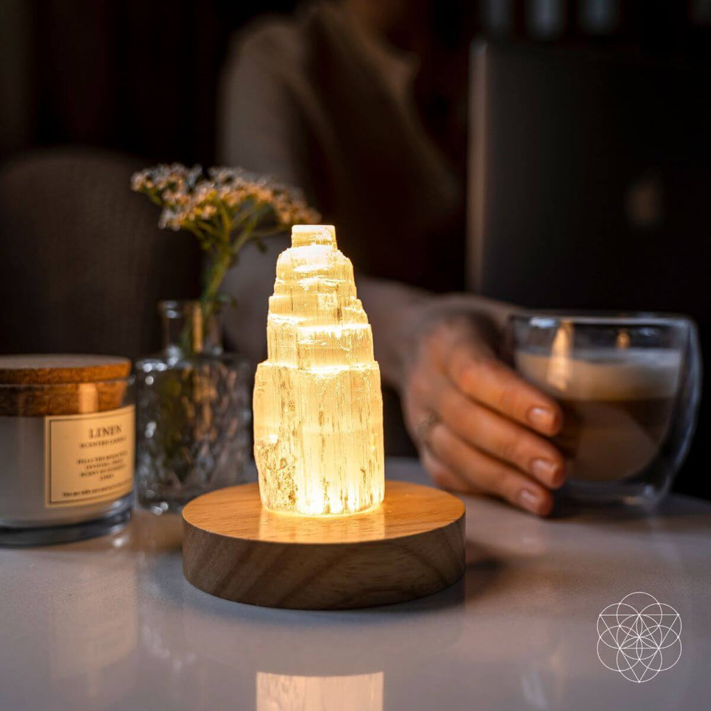 Decorative crystal lamp on a table with a blurred background of a person holding a coffee cup.