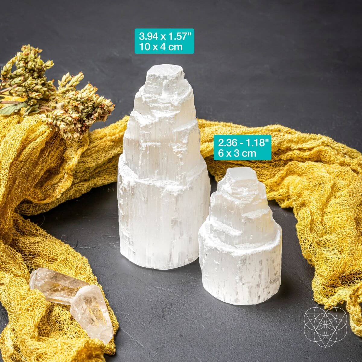 Two white crystal towers on a dark surface with yellow fabric and decorative elements.