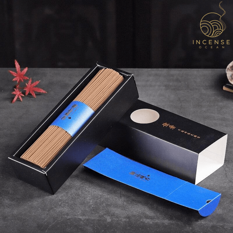 An open box of incense sticks on a black surface.